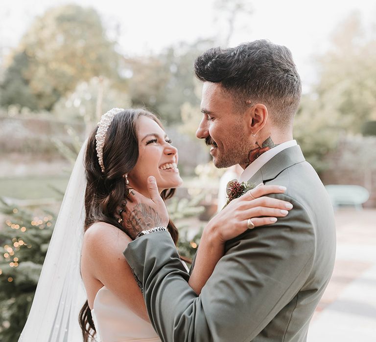 Bride and groom embracing at their outdoor wedding ceremony at Ripple Court Estate in Kent 