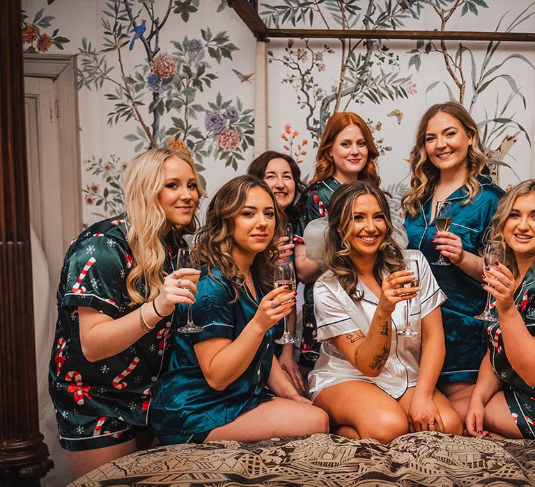 Bridal party wearing blue satin patterned pyjamas as they get ready for the wedding with the bride 