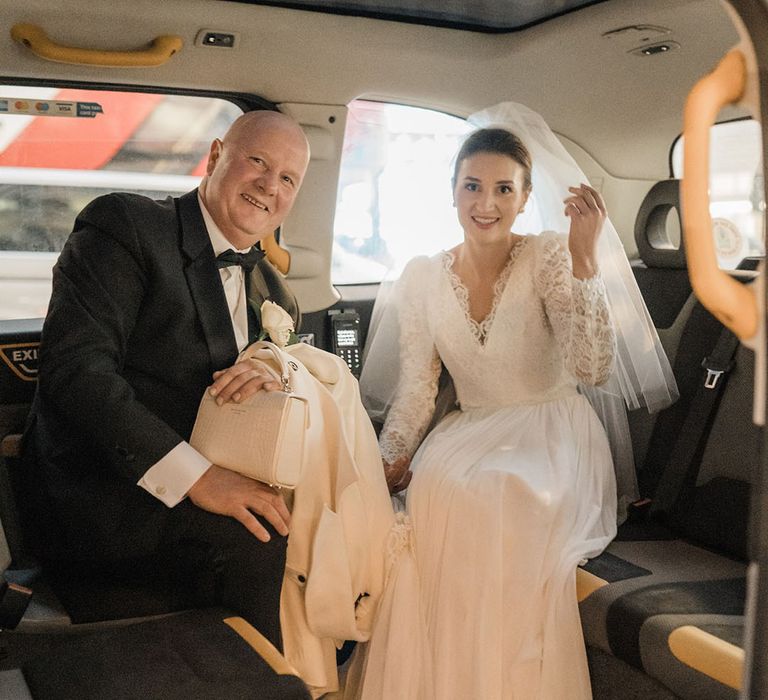 Father of the bride with the bride riding in a black taxi cab 