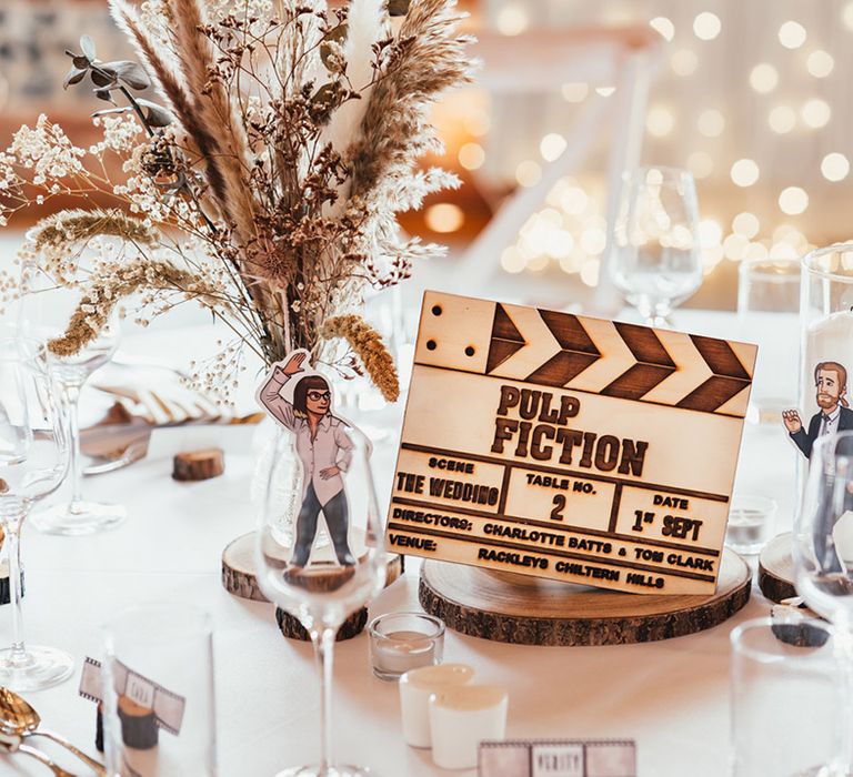 Pulp Fiction table name sign made from wood with illustrated characters with pampas grass and dried flowers 