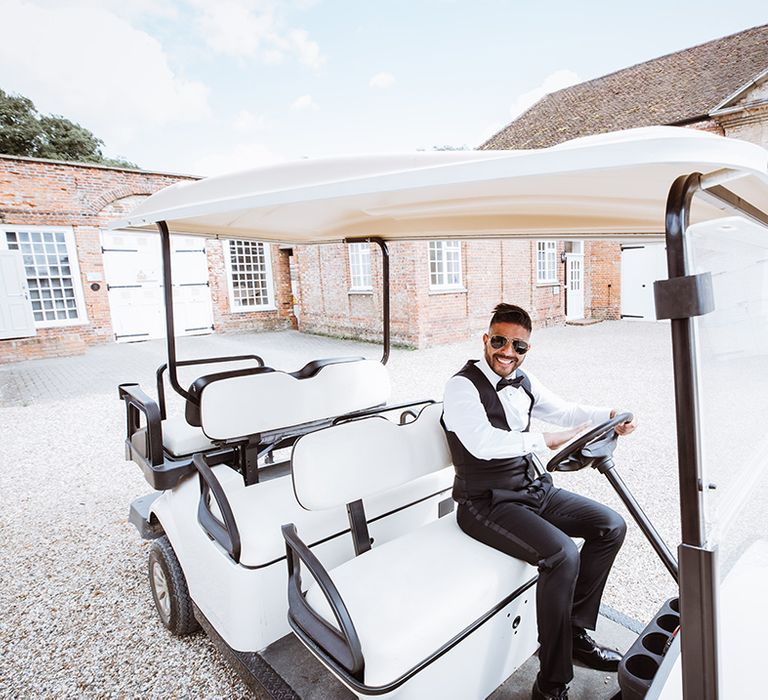 Groom rides around the wedding venue in a golf buggy 