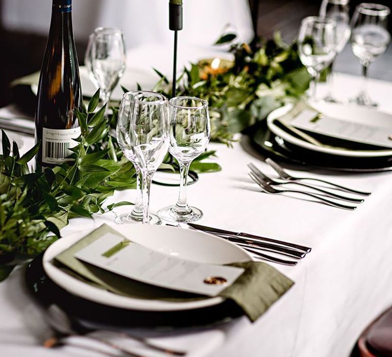 White wedding tablecloth with dark green candles, foliage table runners with green napkins for classic wedding 