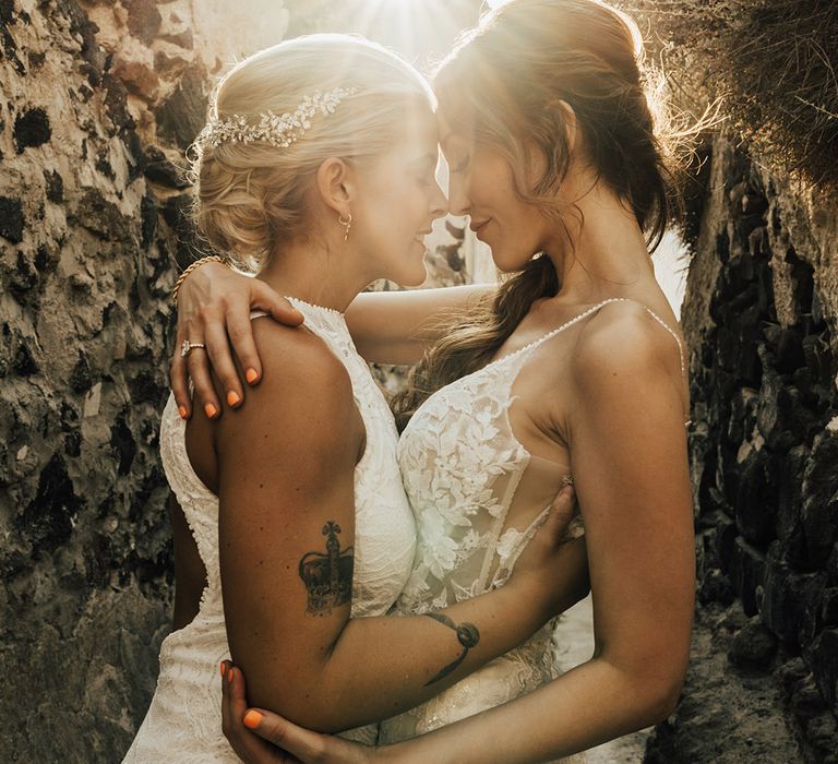 Golden hour couple portrait of two brides at lesbian wedding in lace wedding dresses 