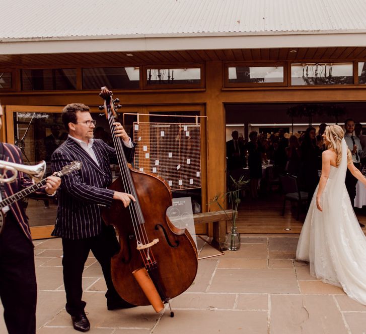 Bride and groom enter wedding breakfast accompanied by wedding band