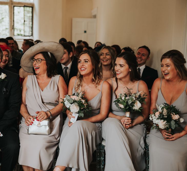 Mother of the bride and bridesmaids laughing and smiling during the wedding ceremony 