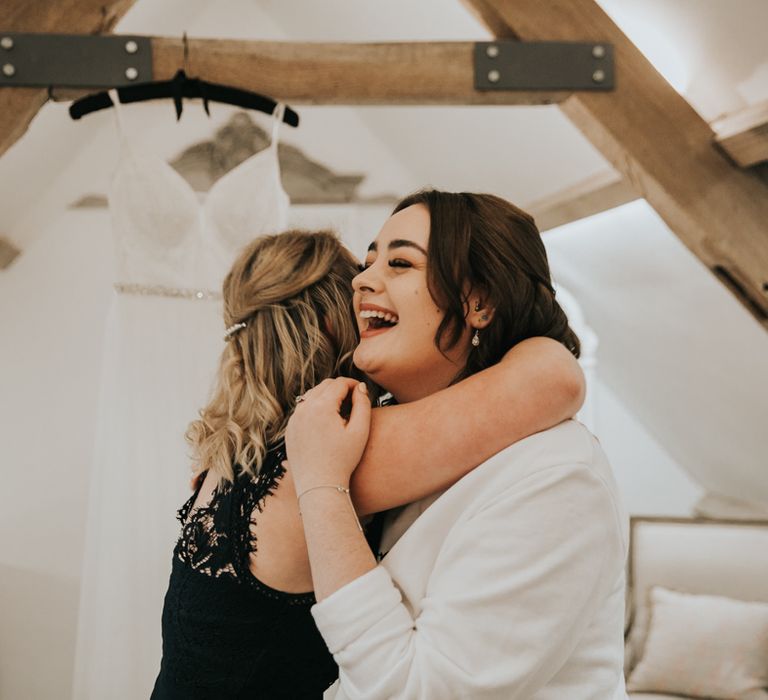 Laughing bride hugging bridesmaid