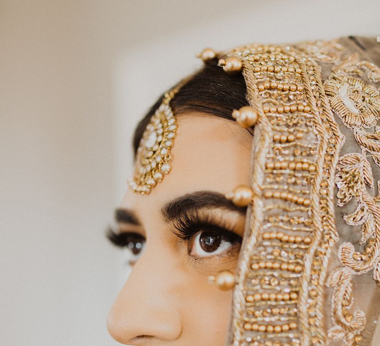 Muslim bride with red lipstick and gold wedding veil 