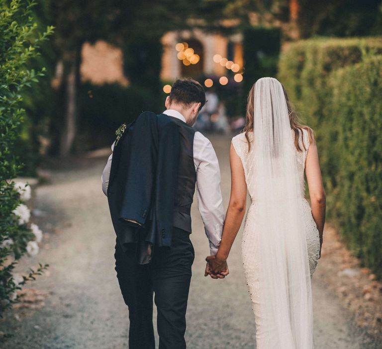 Bride and groom holding hands at Italian outdoor wedding