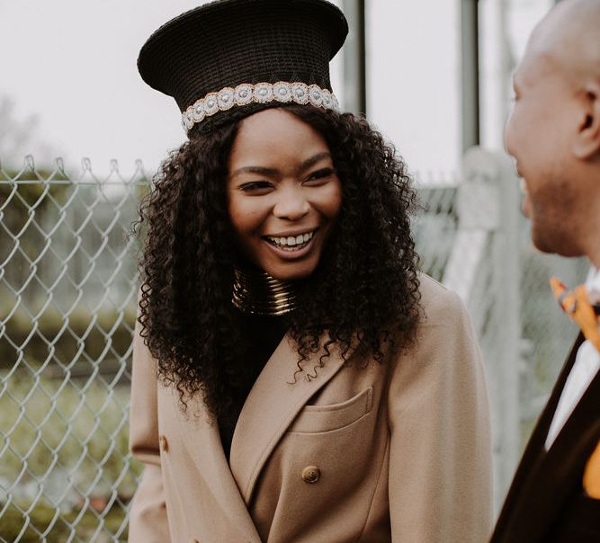 Black African bride in Zulu hat with afro hair smiling at her groom 