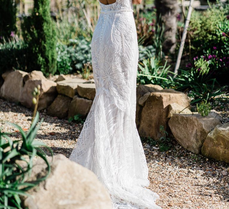 Bride in open back wedding dress poses in botanical garden at Urban Jungle Suffolk