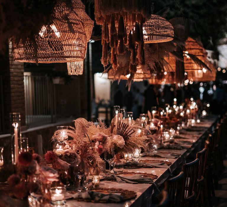 Outdoor wedding reception with shell and macrame hanging installation, candlelight and dried flower centrepieces 