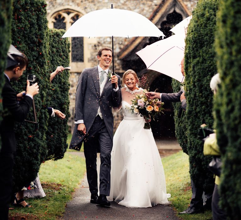 Bride & groom walk through confetti together on wedding day