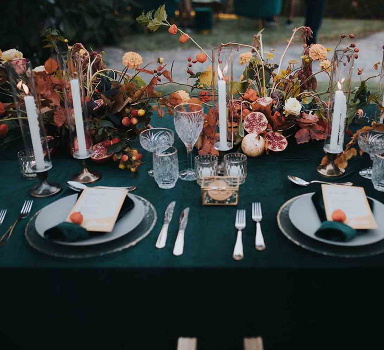 Beautiful table place setting with candles and Autumn colour wedding flowers