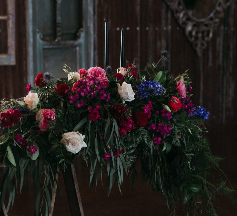 Moody romantic wedding flowers with pink and red peonies and roses, fern foliage and wild flowers