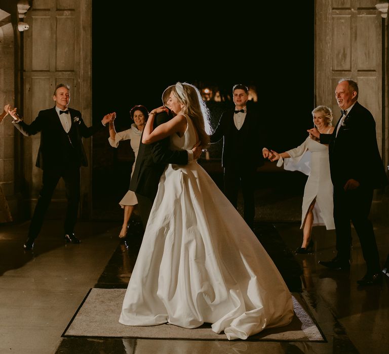 Bride & groom dance outdoors at Markree Castle for first dance moment as wedding party look on