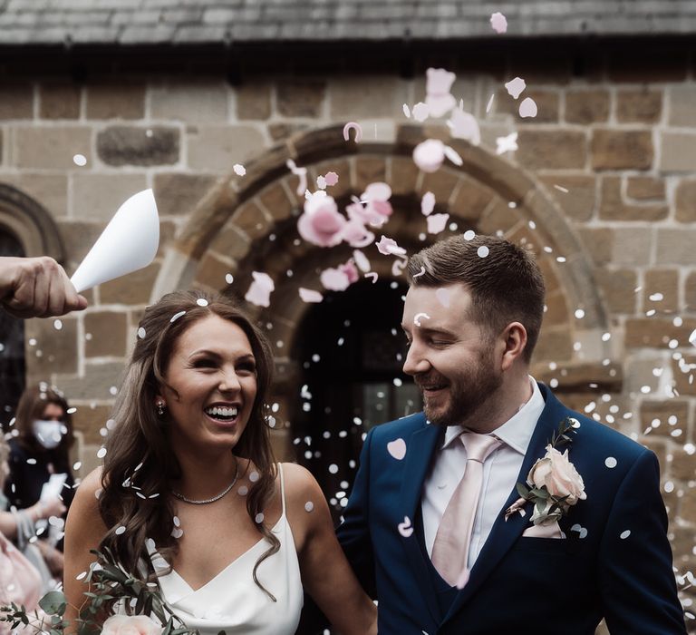 Bride and groom confetti exit at church micro wedding