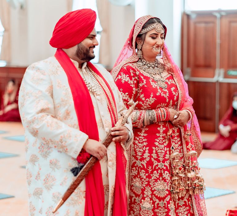 Bride & groom stand with one another during traditional Sikh wedding ceremony