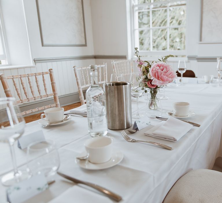 White table clothes for reception with pale pink florals on the table