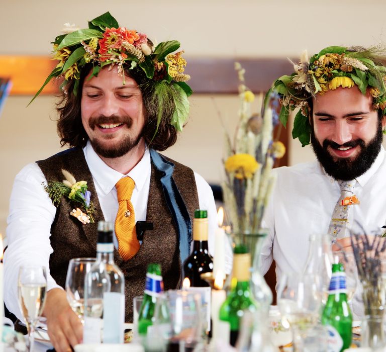 Grooms wear floral crowns on their wedding day as they smile and laugh with one another