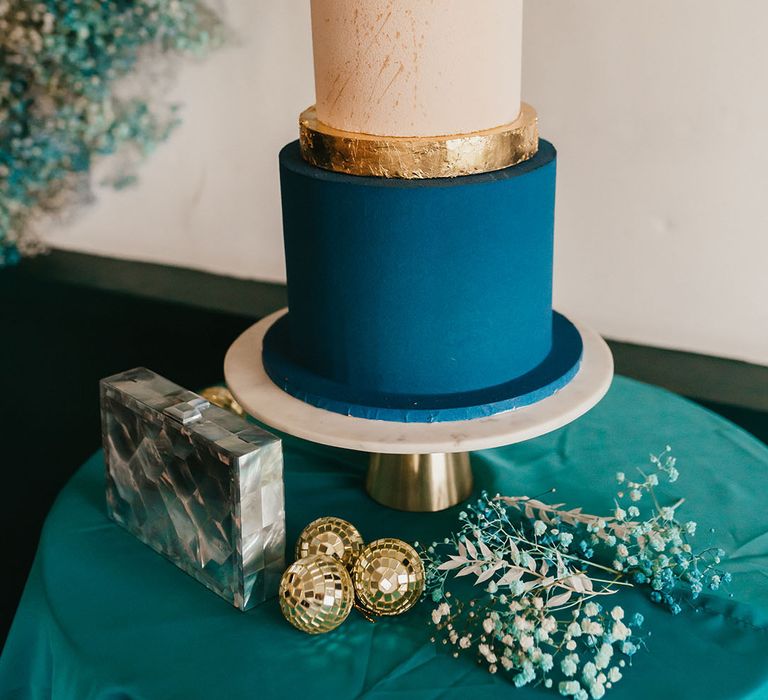 Three tier buttercream wedding cake with teal, cream and white layers and a sugar shard cake topper 