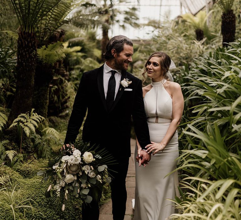 Tatton Park black-tie wedding with groom in a black suit and tie and bride in a halterneck wedding dress and ribbon hair accessory 