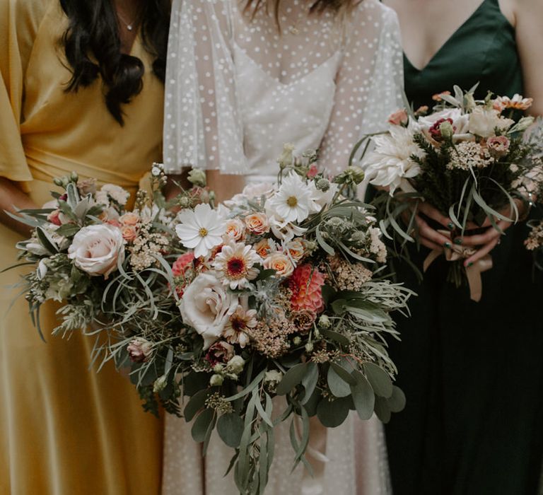 Bride & friends hold floral bouquets complete with neutral tones and sage green accent colour