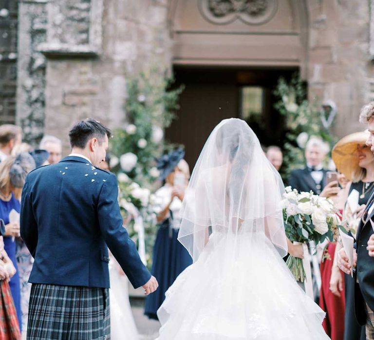 Classic Scottish church wedding with bride in a princess wedding dress and groom in a tartan kilt