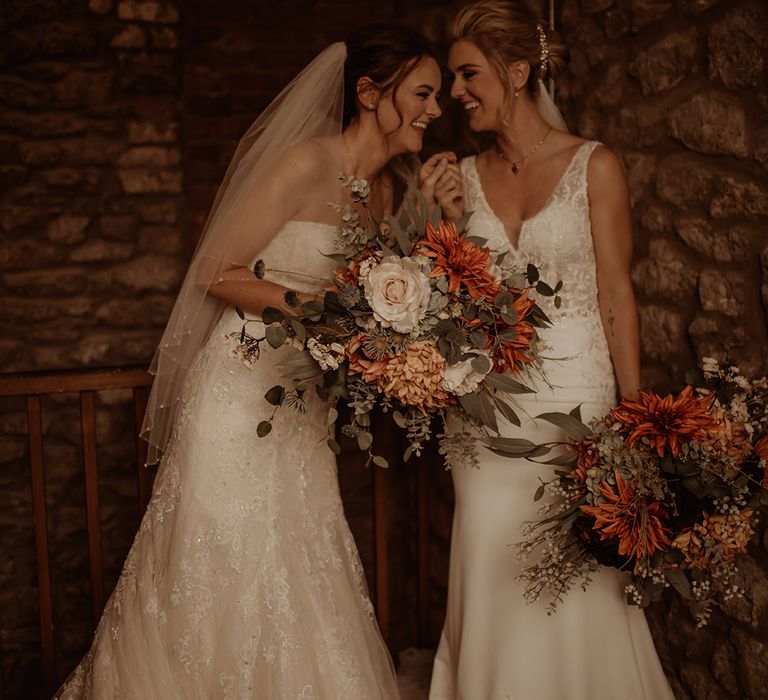 Brides laugh with one another outdoors