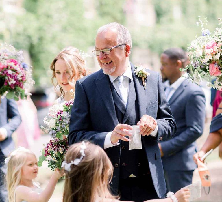 Wedding guest holds confetti for country wedding in the Cotswolds 