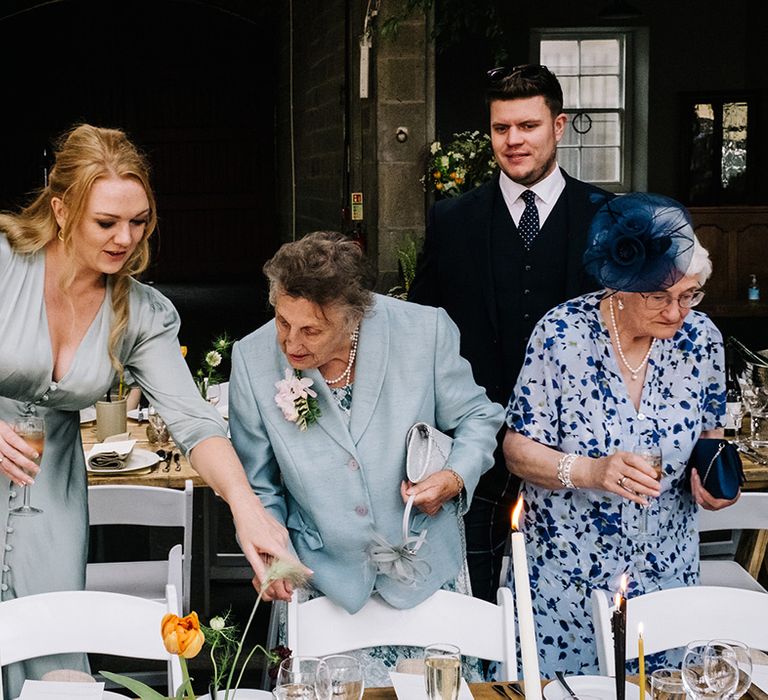 Wedding guests all dressed in blue find their seats for the wedding reception