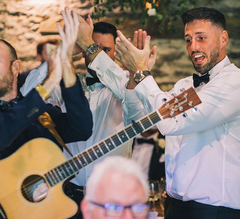 Man playing guitar with microphone part of wandering band 