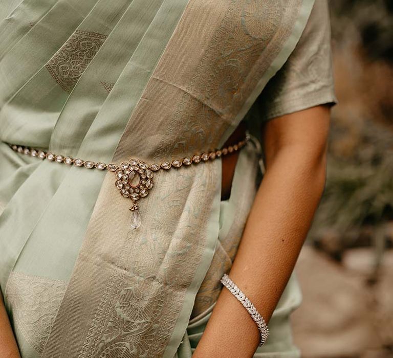 Close up of the mint green saree with golden touches and silver bracelet