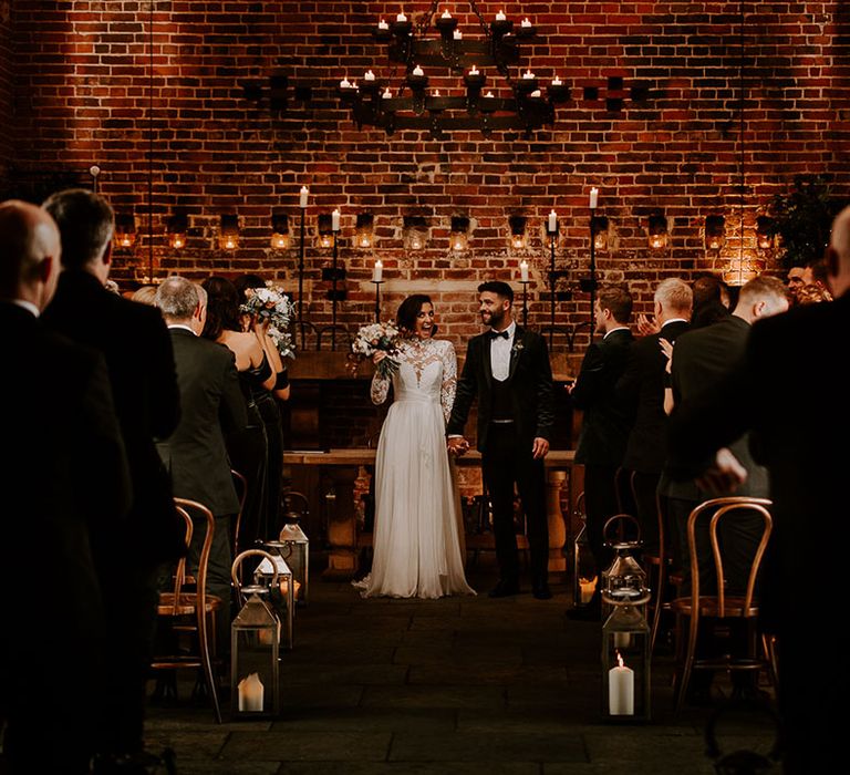 Bride smiles in excitement and happiness as her and the groom are announced as a married couple 