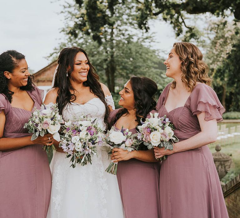 Bride in lace wedding dress with bridesmaids in vintage pink butterfly sleeve dresses 