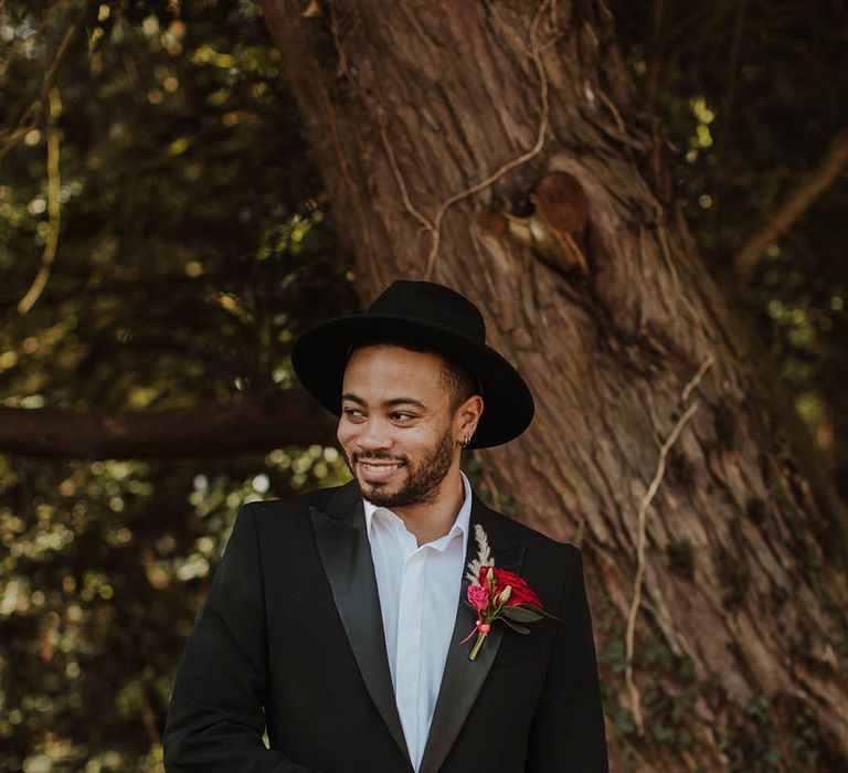 Groom in a black suit jacket with satin lapel and open collar shirt at Prestwold Hall wedding 