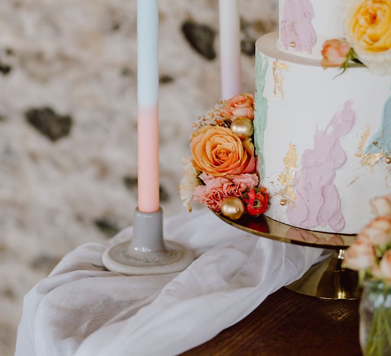 grey candlestick holders and two tone taper candles decorating the wedding cake table 