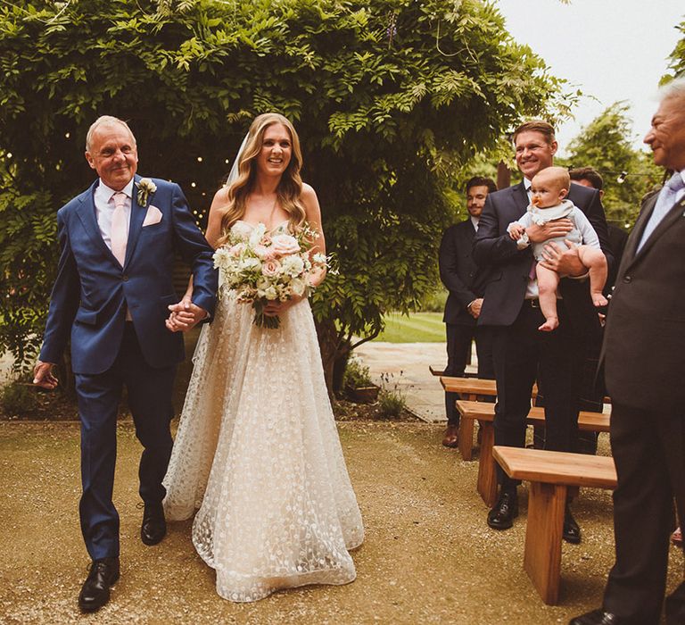 Father of the bride walks the bride in Pronovias strapless wedding dress down the aisle for classic wedding