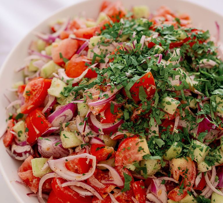 Colourful vegan salad filled with tomatoes potato and onion 