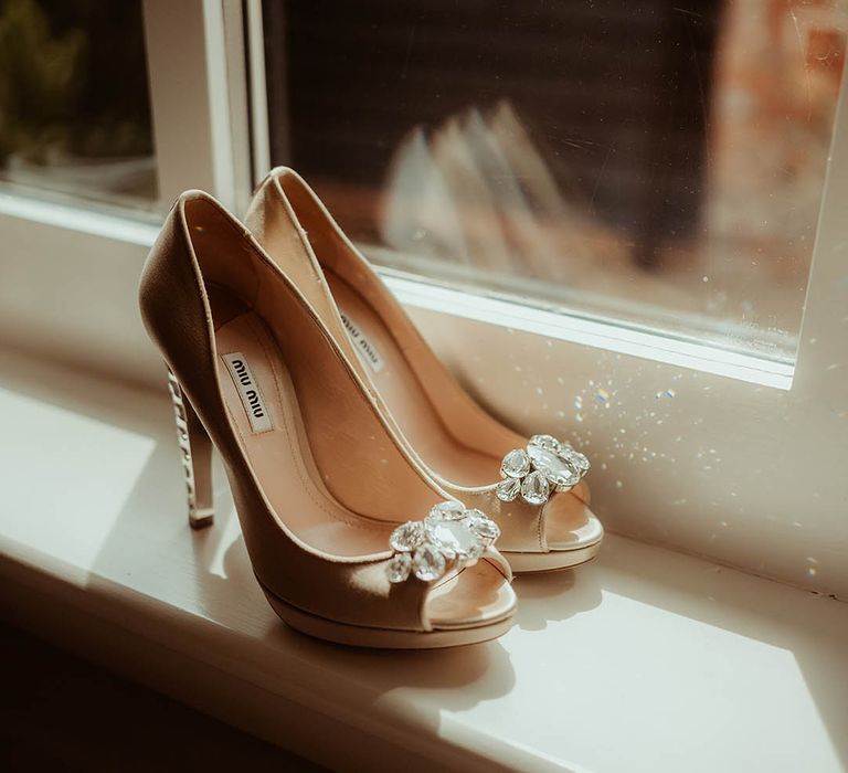 Beige Miu Miu peep toe wedding shoes for the bride with a jewel on the front 