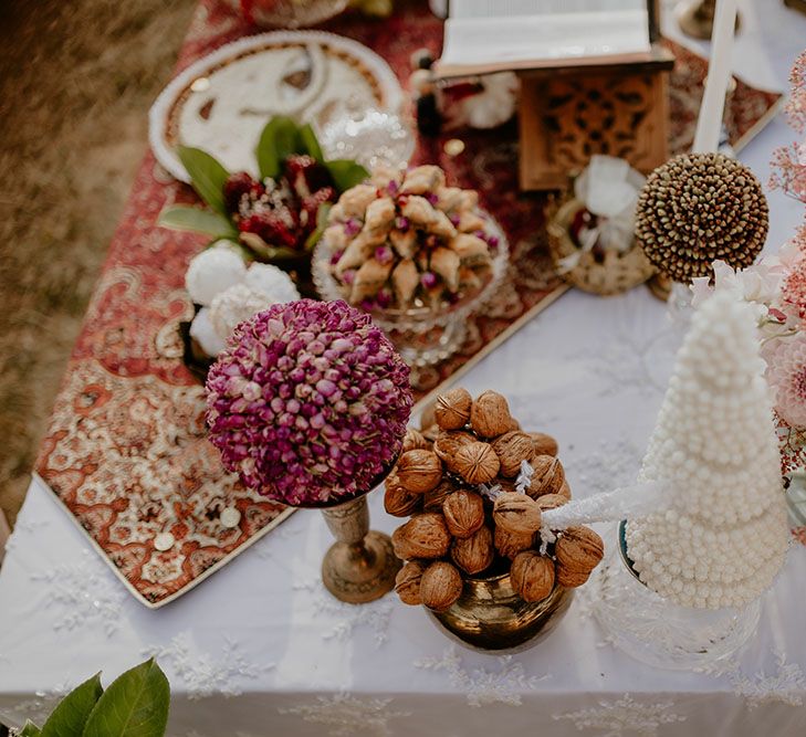 Sofreh Aghd wedding table complete with pink and white wedding flowers on colourful tablecloth 