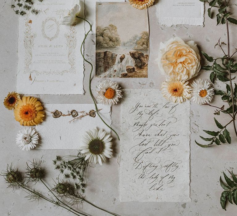 Flat lay of vintage style wedding stationery suite with calligraphy and aged paper 