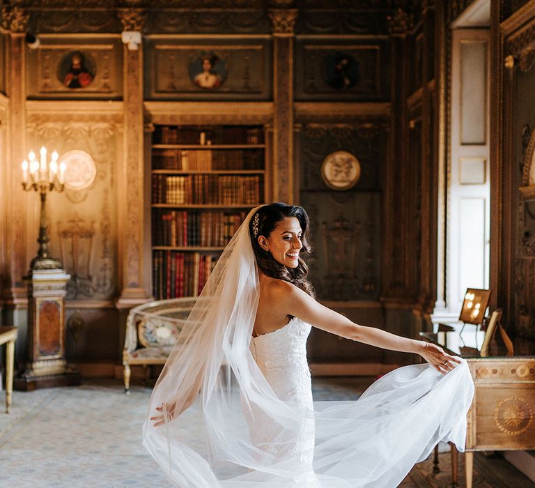 Bride twirls and throws her cathedral veil out to the side 