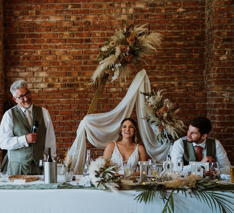 Guests giving speeches at boho rustic wedding tablescape at The Green Cornwall wedding venue