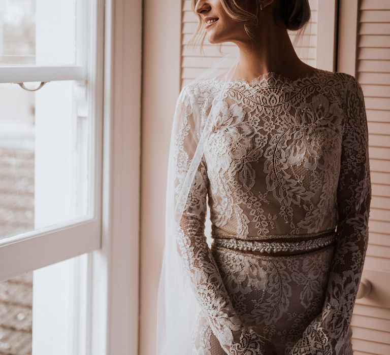 Bride wears Calla Blanche wedding dress with long sleeves and illusion lace waistband 