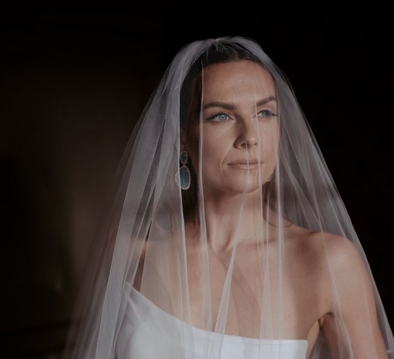 Bride in strapless satin wedding dress with sheer two tier veil and silver lining 