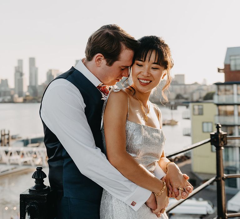 Groom embraces his bride during golden hour portraits 