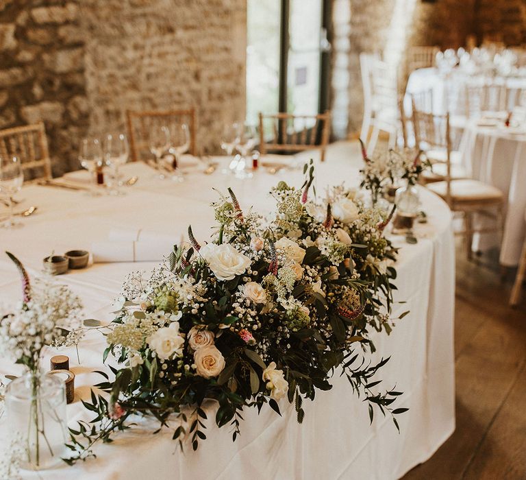 The top table decorated with wedding flower arrangement of pink and white flowers 