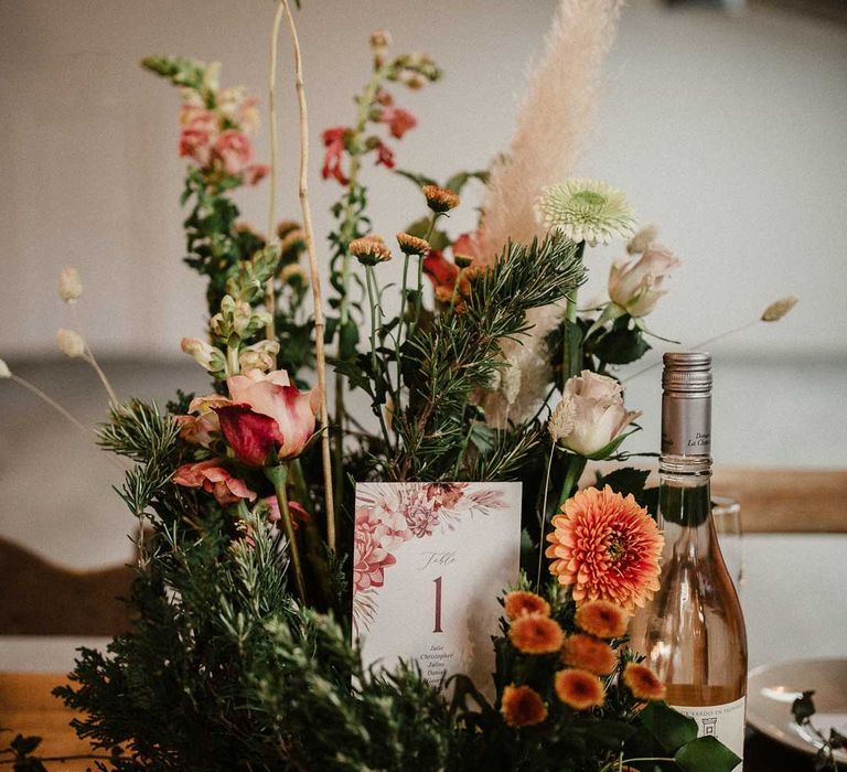 Foliage, garden rose, pampas grass and dried flower boho centrepiece on rustic wedding tablescape at The Barn at Avington