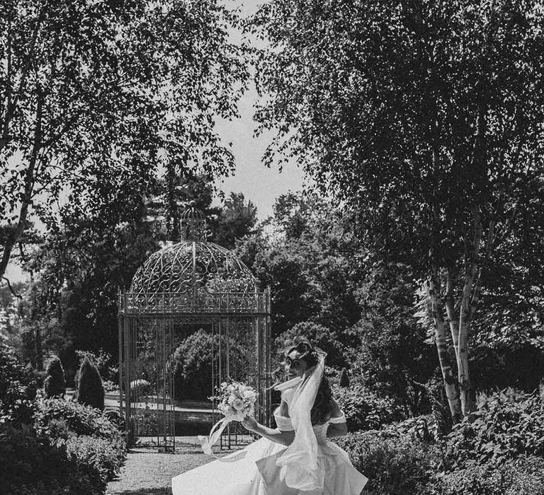 bride in a strapless princess wedding dress running through the gardens at Capesthorne Hall