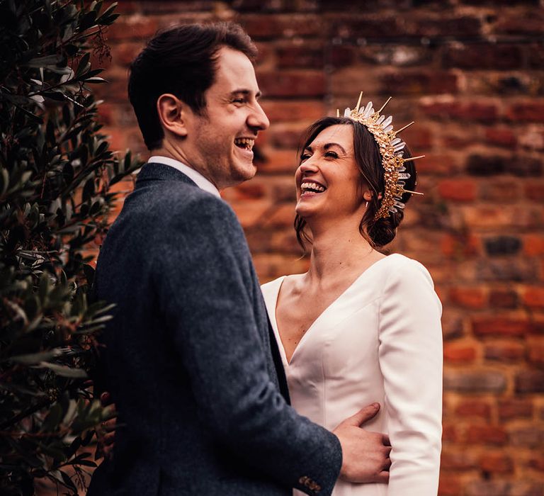 Groom in navy tweed suit with the bride wearing a crystal bride crown with long sleeve wedding dress 